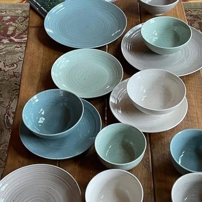 A vibrant multicolored dish set elegantly arranged on a dining table.