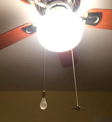 Long chains adorned with charms shaped like a lightbulb and a fan