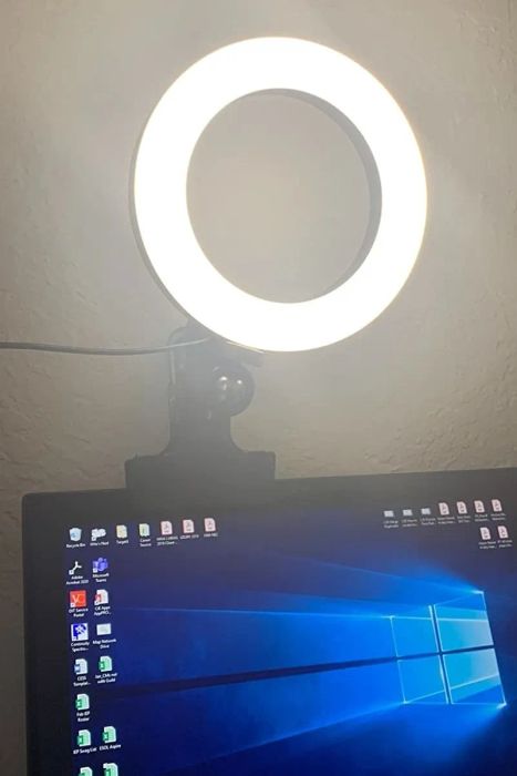A reviewer's photo of the illuminated ring light clipped to the top of a laptop screen.
