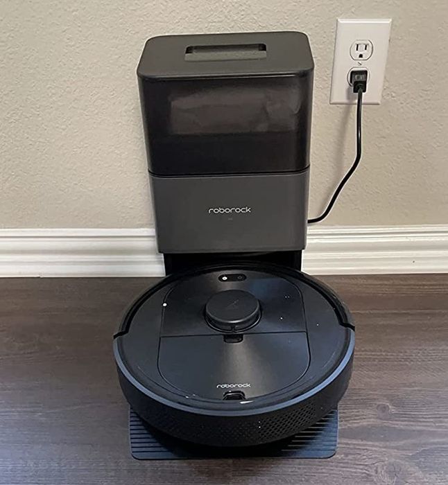 Roborock vacuum stationed at its docking base.