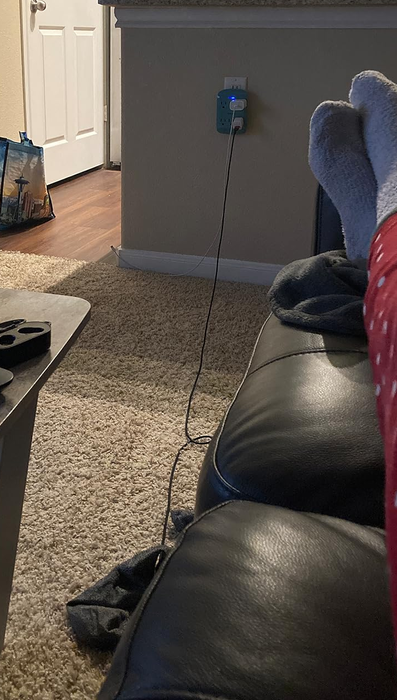 A charger stretched from the outlet to the couch, providing a convenient power source.