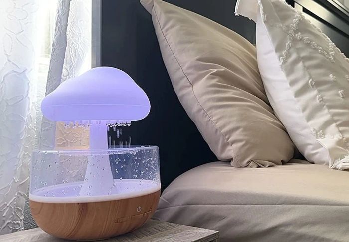 A reviewer's cloud-shaped diffuser displayed on a bedside table