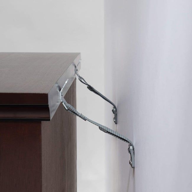 Two sturdy straps are installed, securing both the large piece of furniture and the wall, preventing any accidents.
