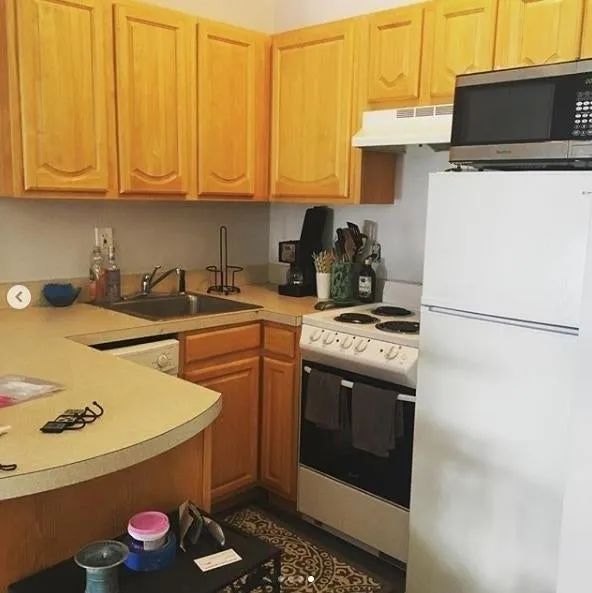A reviewer's photo showing their kitchen with outdated cabinets, ready for a makeover.