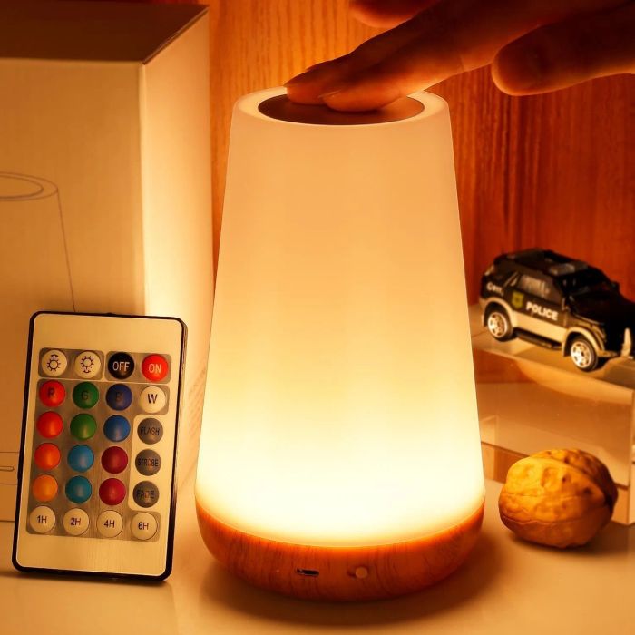 A hand adjusting a modern lamp with a color-changing remote, perfect for enhancing your home's ambiance