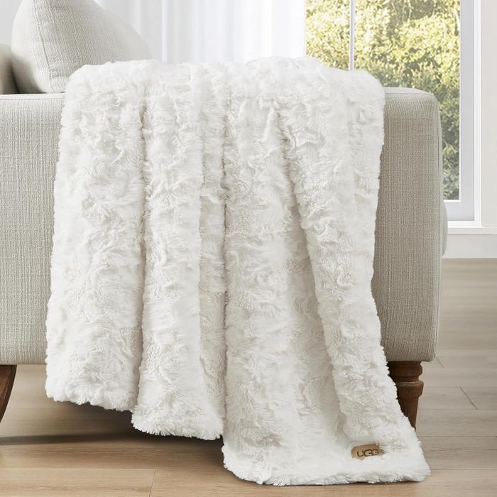 A plush faux fur throw blanket casually draped over a sofa, offering both warmth and style to any cozy space.