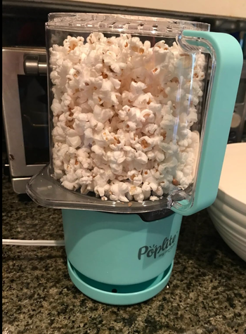 A countertop air popper brimming with freshly popped popcorn, clearly labeled.