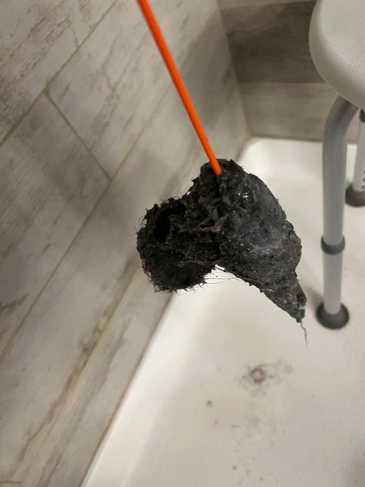 The drain snake with a glob of hair stuck to its end