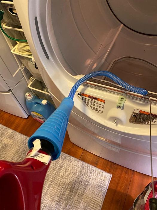 The vacuum hose connected to clean out the lint trap.