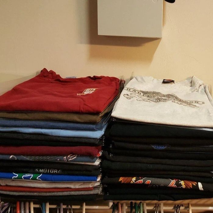 Neatly arranged stacks of T-shirts on a shelf after using the closet organizer *and* shirt folder