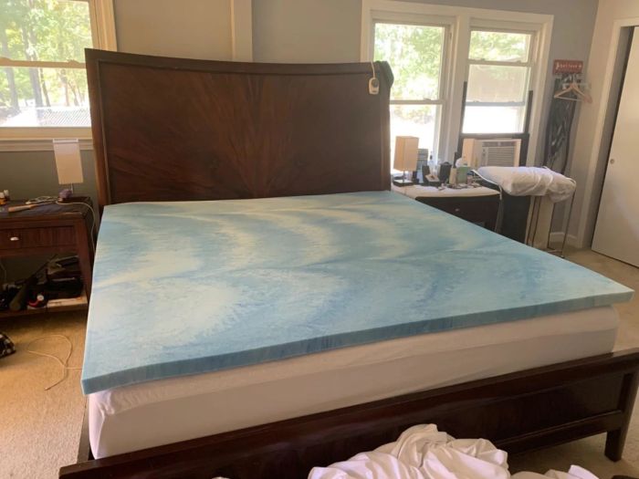 A mattress in a peaceful bedroom with a memory foam topper added, suggesting an upgrade for enhanced bedding comfort