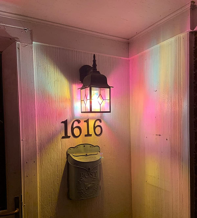 A reviewer image of the lightbulb placed in a sconce on a porch