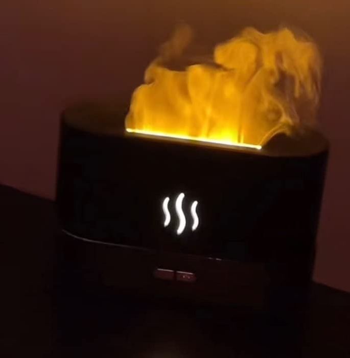 An electronic aromatherapy diffuser creating a glowing steam effect