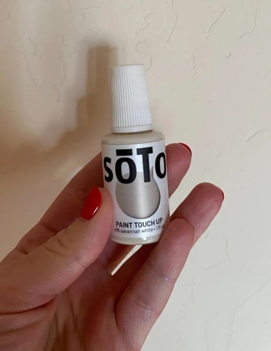 A customer review image showing them holding the paint beside the freshly painted wall