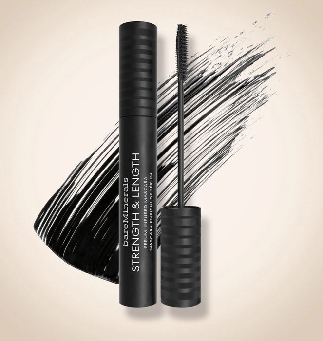 A mascara tube and brush with a dramatic black mascara swipe in the background