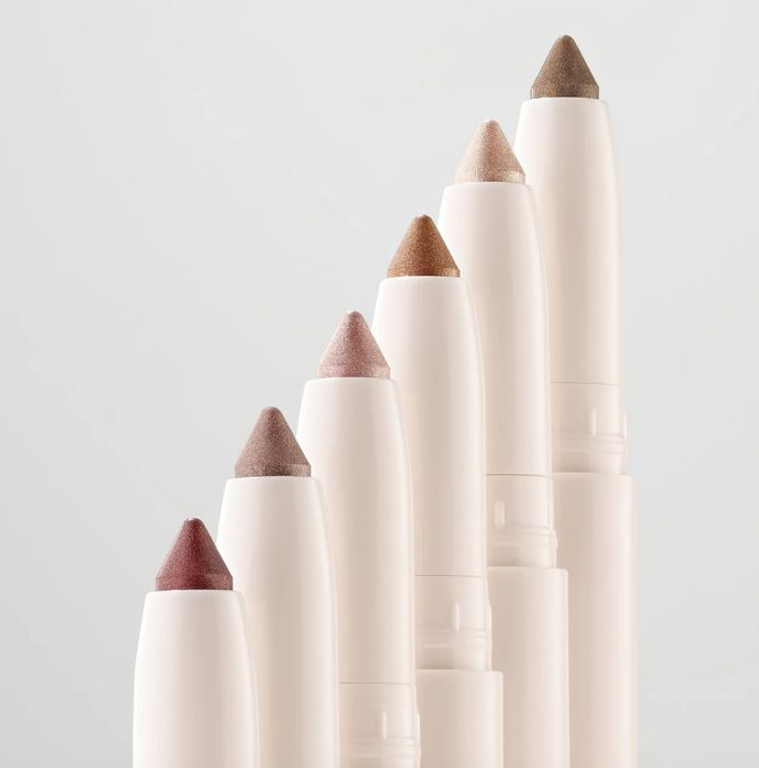 A collection of six eyeshadow sticks in neutral shades, beautifully arranged in a tiered formation.