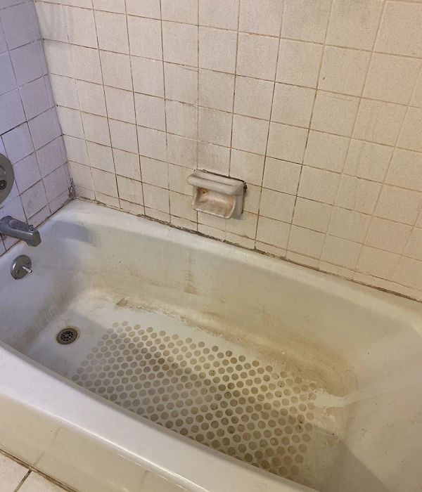 A reviewer’s photo of a dirty bathtub before cleaning
