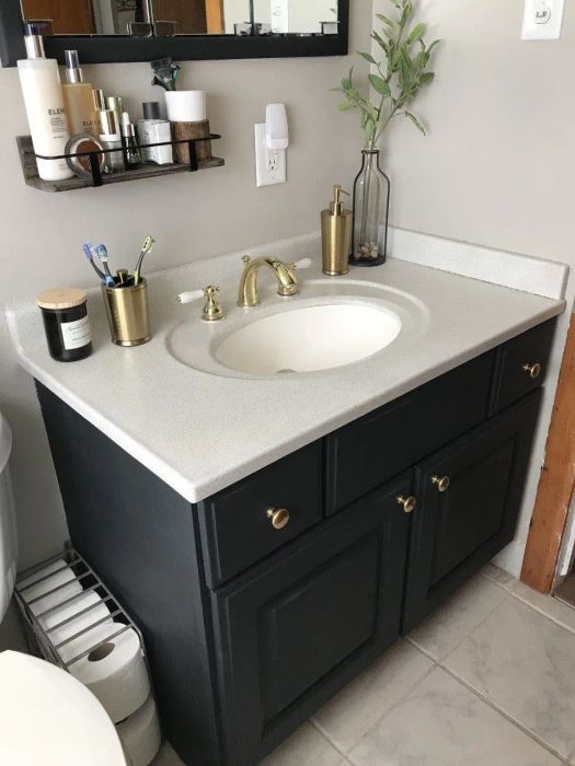 A reviewer's image showcasing the transformation of the bathroom vanity after using the spray paint.