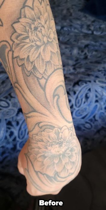 A reviewer showing a photo of their tattooed arm