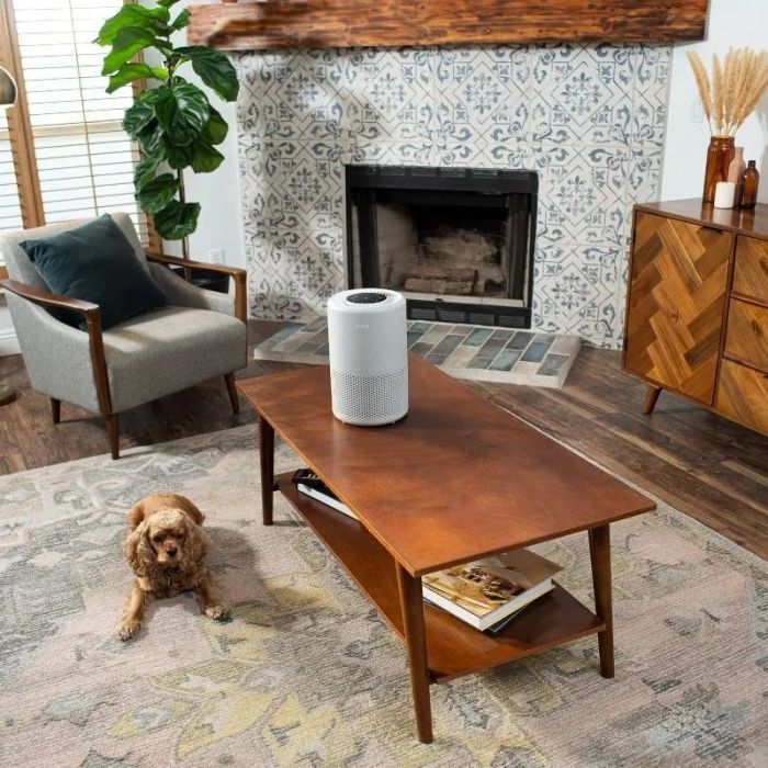 The air purifier placed on a coffee table in a cozy living room, improving the home's air quality.