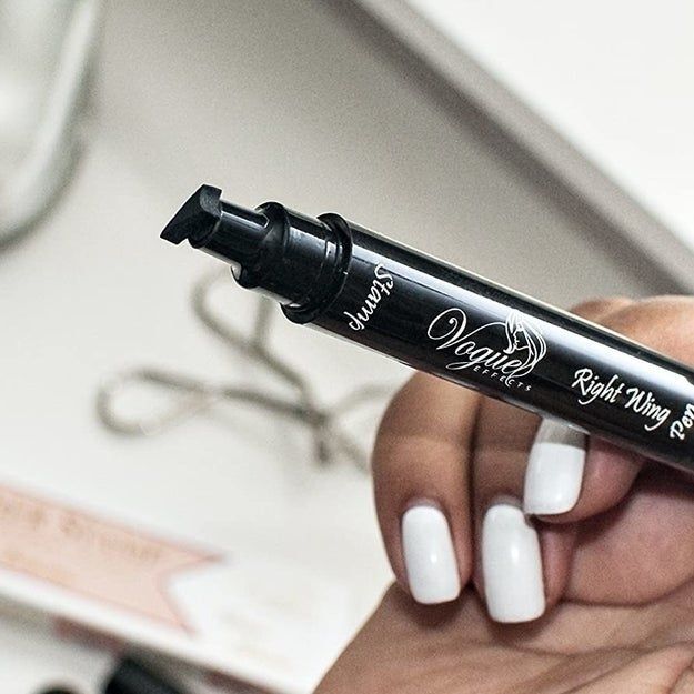 Model holding an eyeliner pen with a wing-shaped stamp