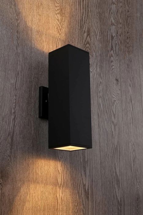 A matte black rectangular sconce mounted on a wall.