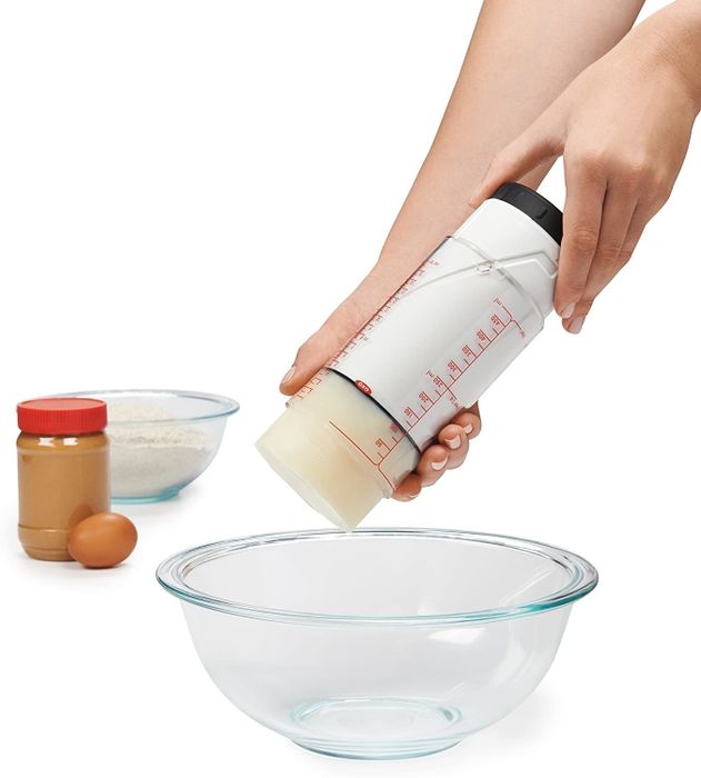 Hands adjusting the bottom of the cup to push out a thick substance