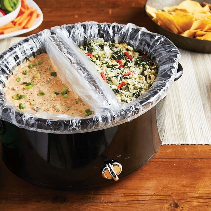 A slow cooker with two dips inside, separated by plastic liners.