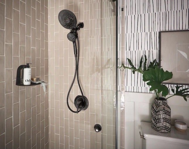 a matte black shower head mounted in a shower stall