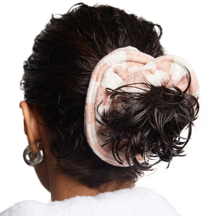 Rear view of a person with wet hair held up by a plush, textured scrunchie