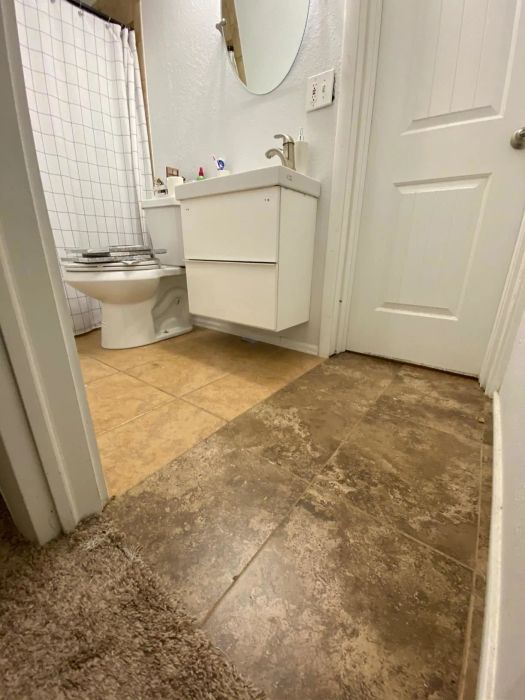 A 'before' image of a bathroom featuring two different shades of brown tiles.