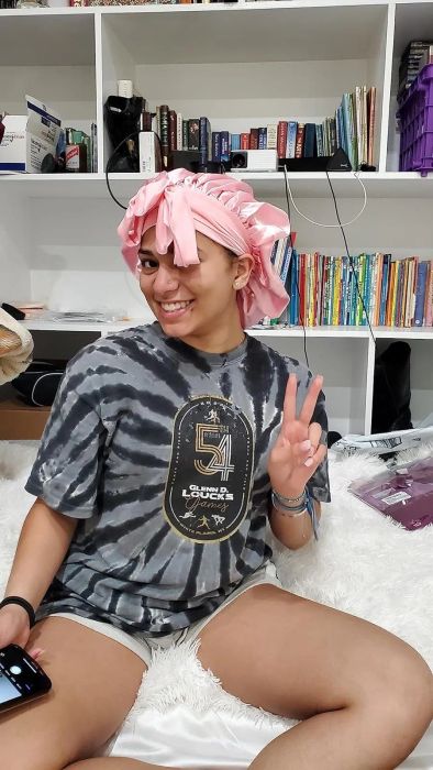 Reviewer posing wearing the bonnet in pink