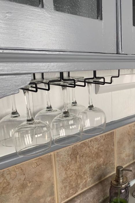 A reviewer's wine glass rack placed under kitchen cabinets.
