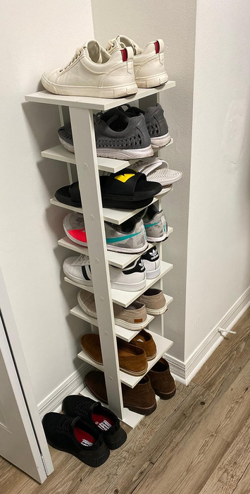A reviewer’s photo of the shoe rack stacked with sneakers