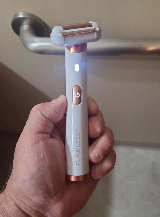 Hand holding a Flawless-brand electric shaver, perfect for personal grooming and maintenance