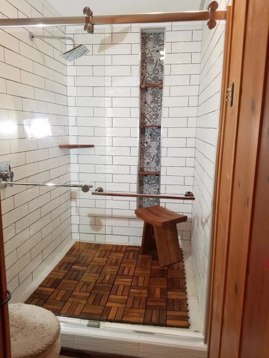 A reviewer's shower featuring interlocking tiles covering the floor.