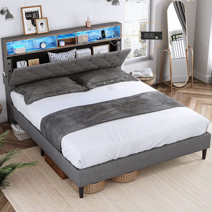 A modern bedroom featuring a gray upholstered bed with a built-in shelf headboard and storage baskets beneath the frame, maximizing both style and space