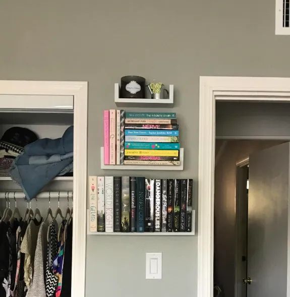Another reviewer's floating shelves displayed between two doorways, with the lower shelves holding books and the top shelf featuring a candle.