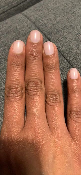A reviewer wearing the pale pink version
