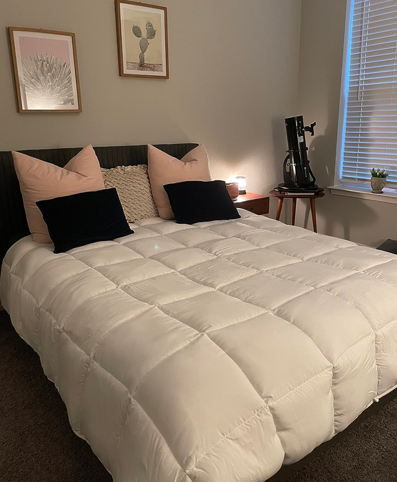 A reviewer’s white all-season comforter neatly laid on a bed