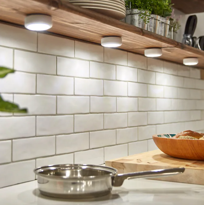 A set of under-cabinet lights illuminating a kitchen space