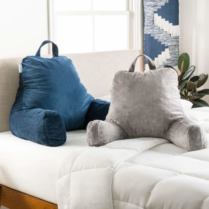A blue and grey backrest pillow, complete with arms and a top handle for easy maneuverability, is displayed.