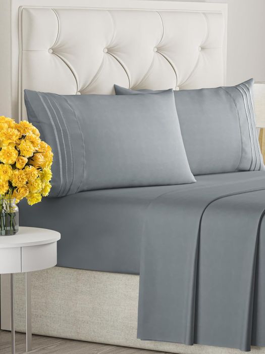 Gray bed sheets neatly arranged on a bed with matching pillows