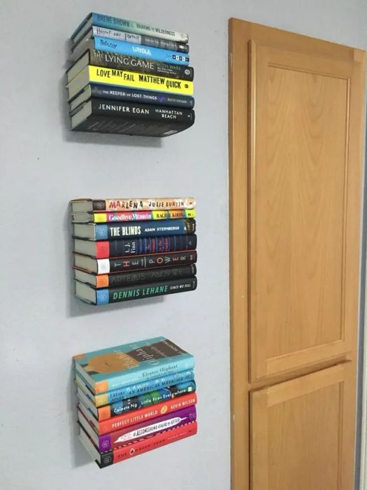 A reviewer's image showing three floating shelves on the wall, each holding a different stack of books.