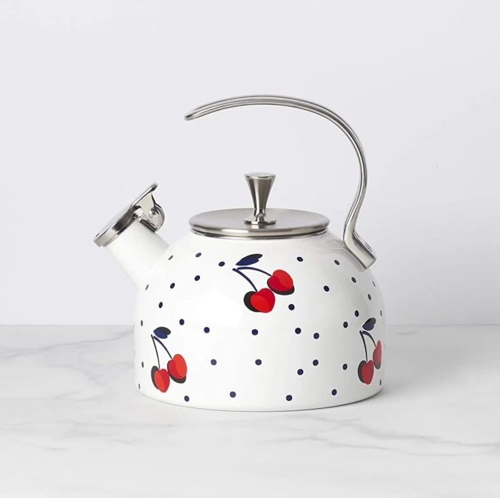 A white kettle with polka dots and a cherry pattern