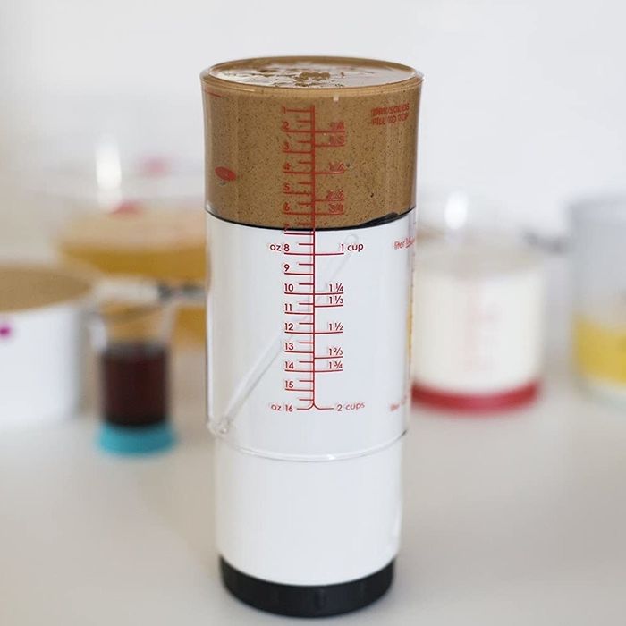 The measuring cup set to a smaller size, now filled with batter