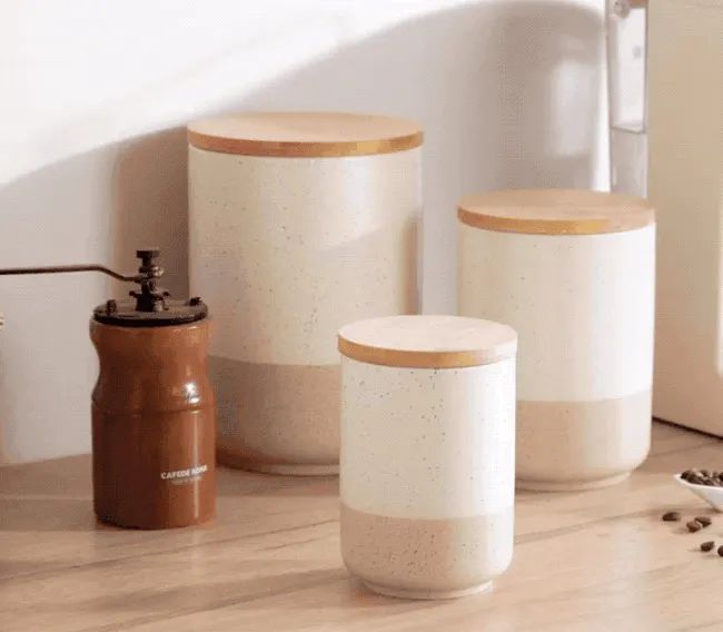 A model scooping coffee beans from a ceramic canister with a spoon