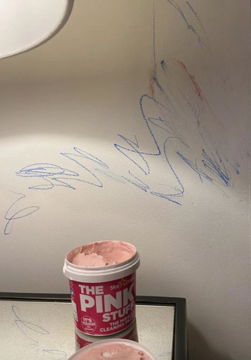 A customer's before photo showing a white wall covered in crayon scribbles