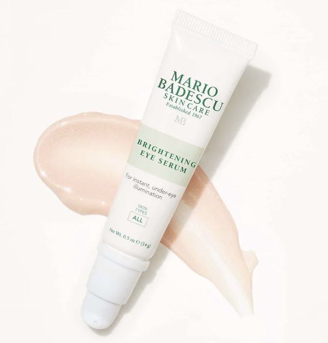 Tube of Mario Badescu Brightening Eye Serum resting on a creamy smear