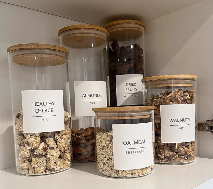 A reviewer's canisters filled with oatmeal, almonds, dried fruit, walnuts, and trail mix on display.